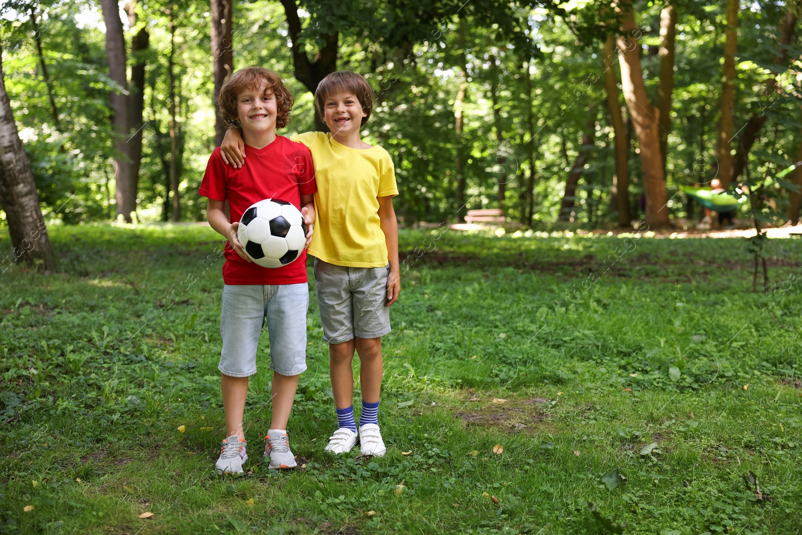 Photo of Cute little kids with soccer ball in park, space for text