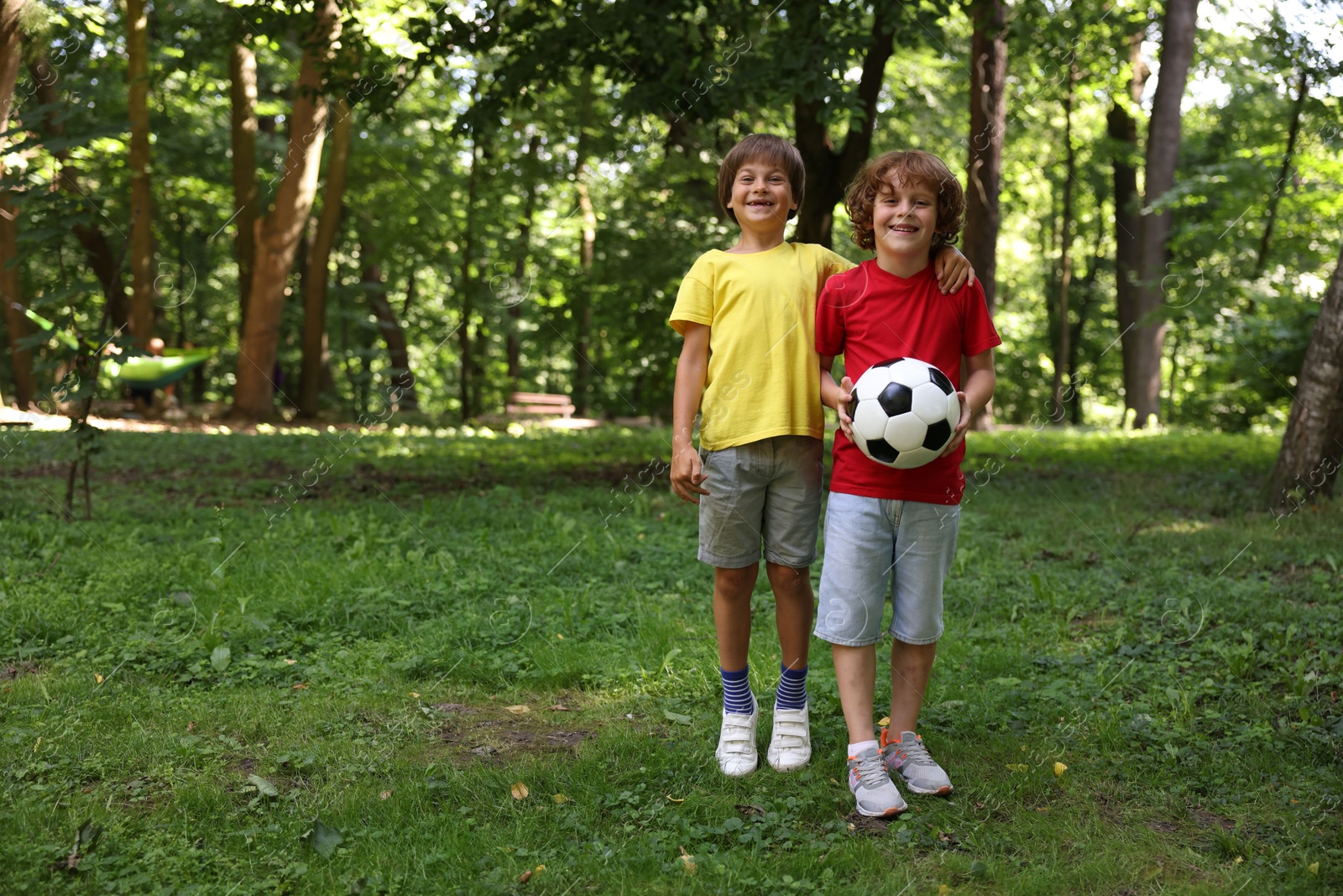 Photo of Cute little kids with soccer ball in park, space for text