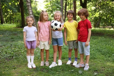 Photo of Cute little kids with soccer ball in park