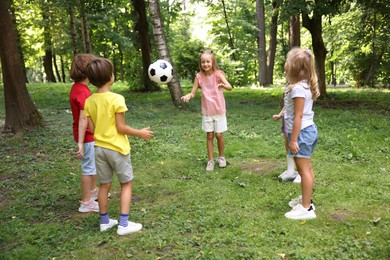 Photo of Cute little kids playing with soccer ball in park