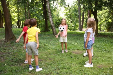 Photo of Cute little kids playing with soccer ball in park