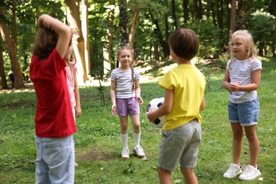 Photo of Cute little kids playing with soccer ball in park