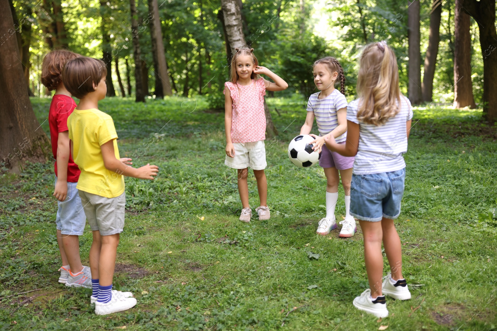 Photo of Cute little kids playing with soccer ball in park