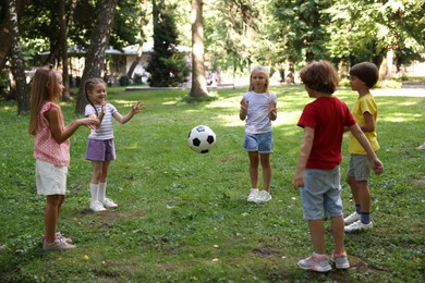 Photo of Cute little kids playing with soccer ball in park