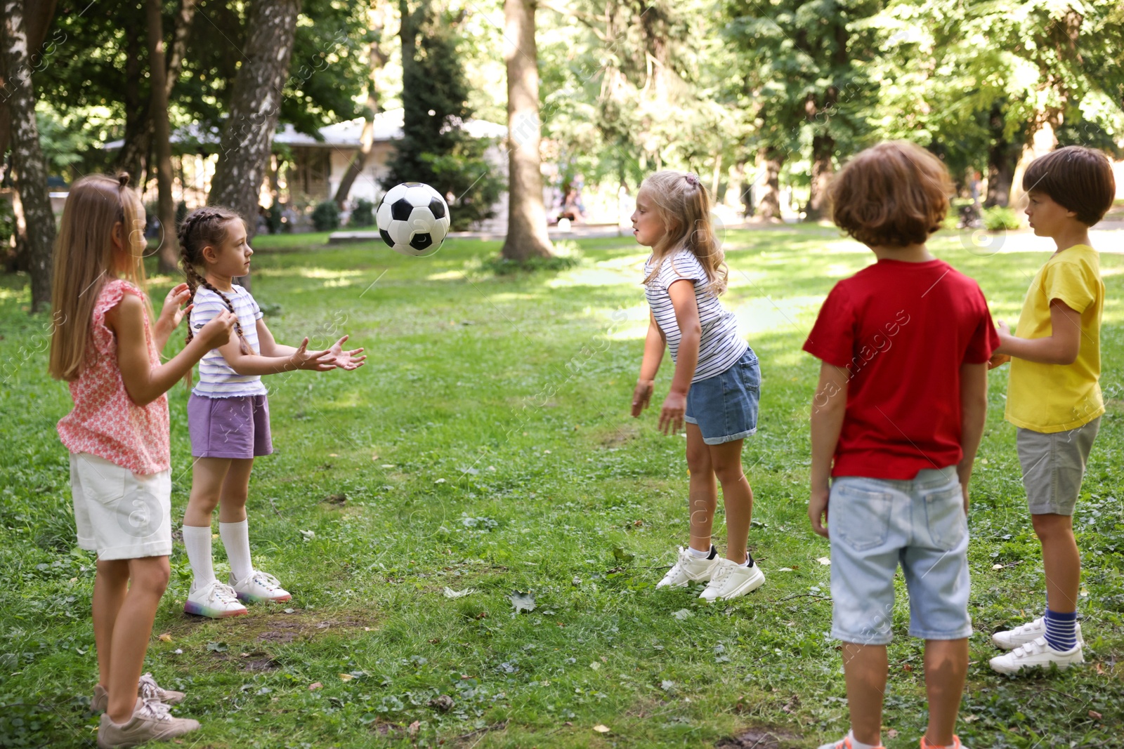 Photo of Cute little kids playing with soccer ball in park