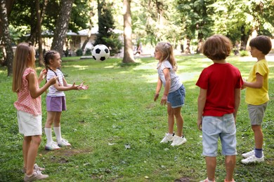 Photo of Cute little kids playing with soccer ball in park