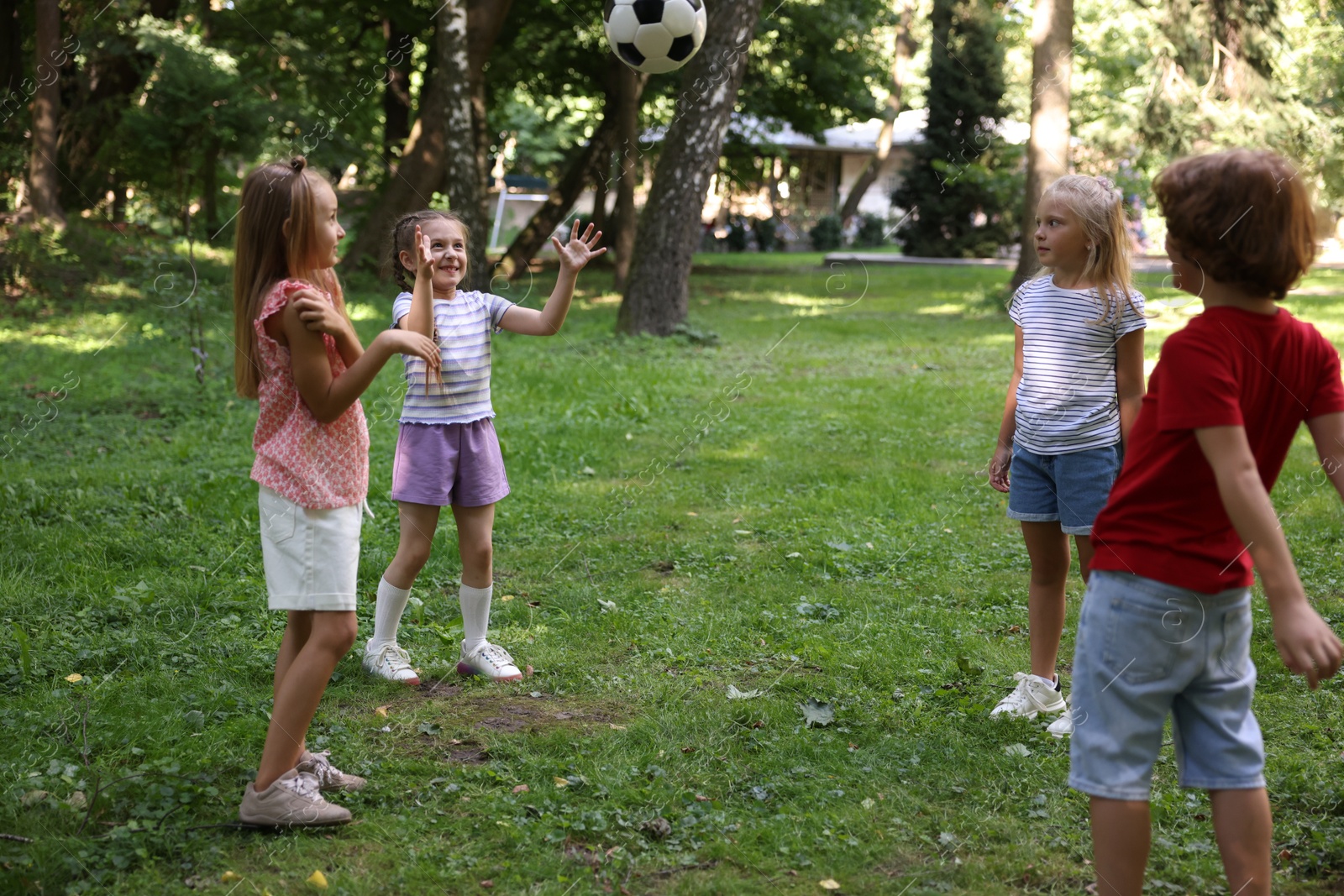 Photo of Cute little kids playing with soccer ball in park
