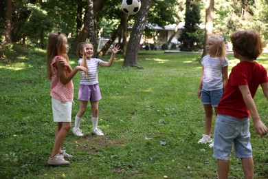Photo of Cute little kids playing with soccer ball in park