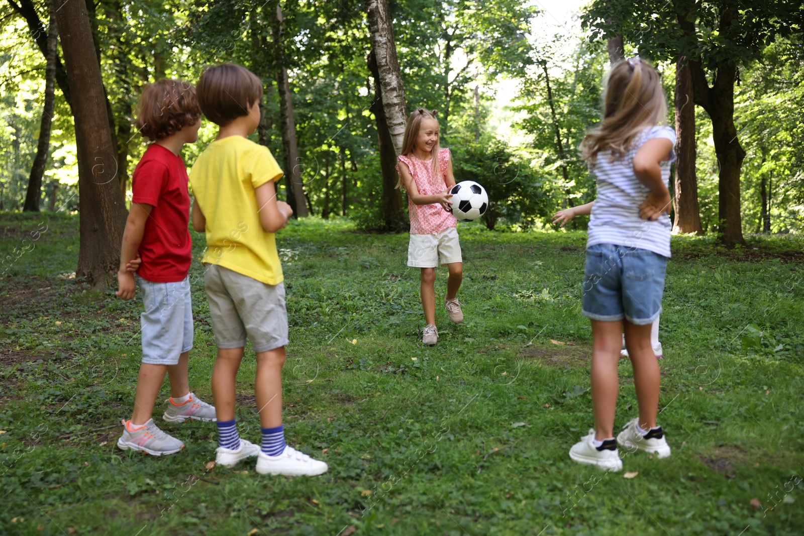 Photo of Cute little kids playing with soccer ball in park
