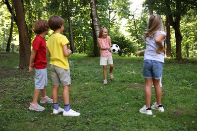 Photo of Cute little kids playing with soccer ball in park