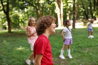 Photo of Cute little kids having fun together in park, selective focus