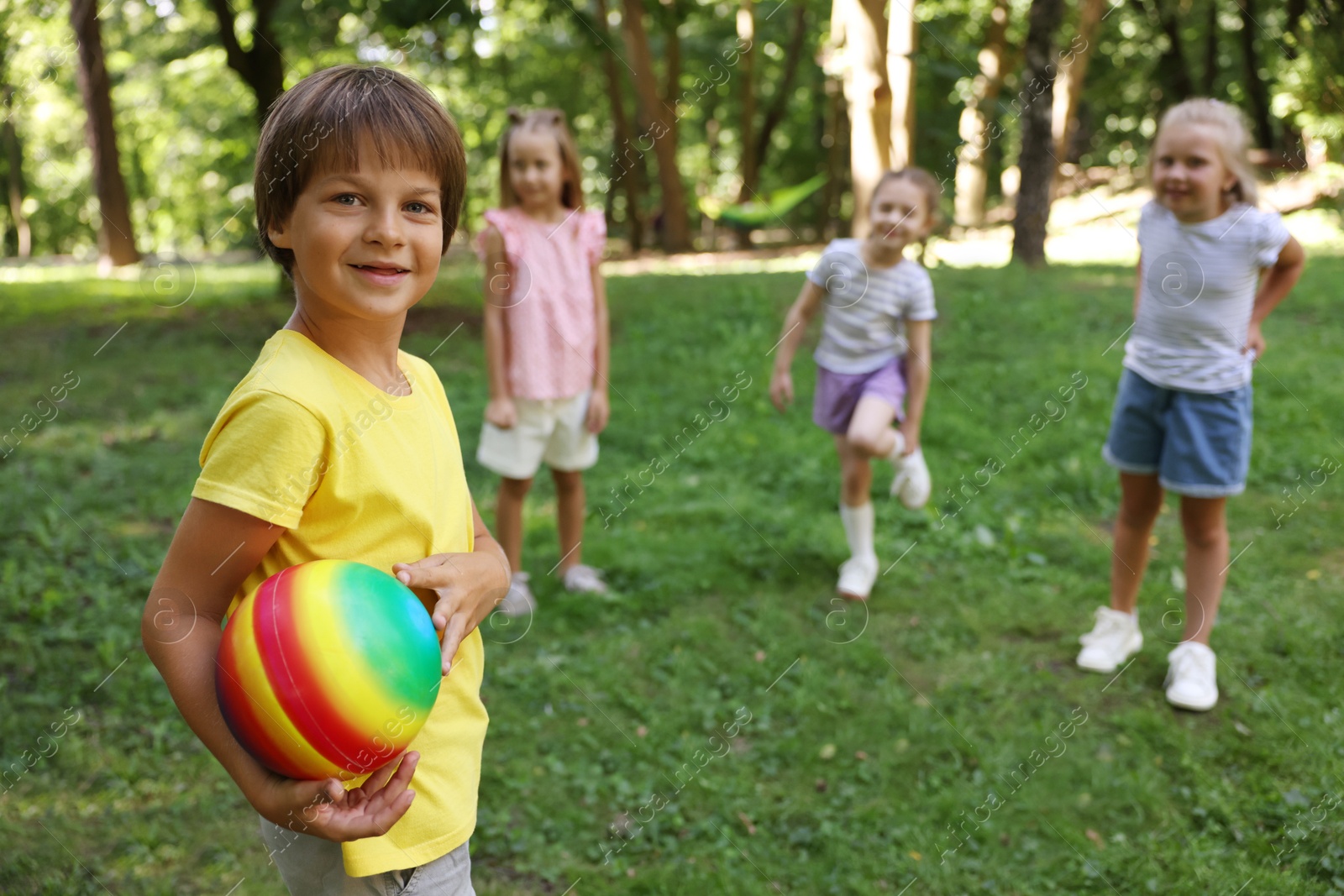 Photo of Cute little kids playing with ball in park, selective focus
