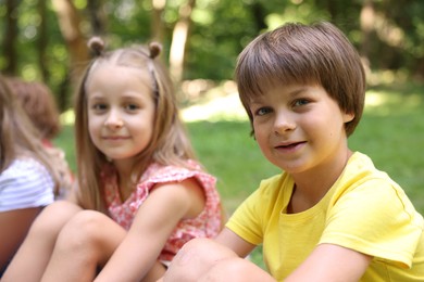Photo of Cute little kids spending time together in park, selective focus