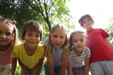 Photo of Cute little kids having fun together in park, low angle view