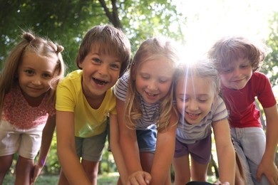 Photo of Cute little kids having fun together in park, low angle view