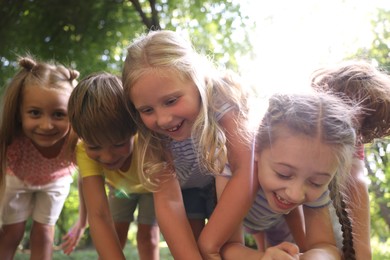 Photo of Cute little kids having fun together in park, low angle view