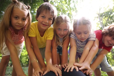 Photo of Cute little kids having fun together in park, low angle view
