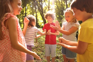 Photo of Cute little kids playing rock, paper and scissors in park