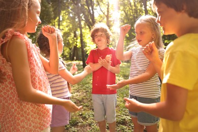 Photo of Cute little kids playing rock, paper and scissors in park