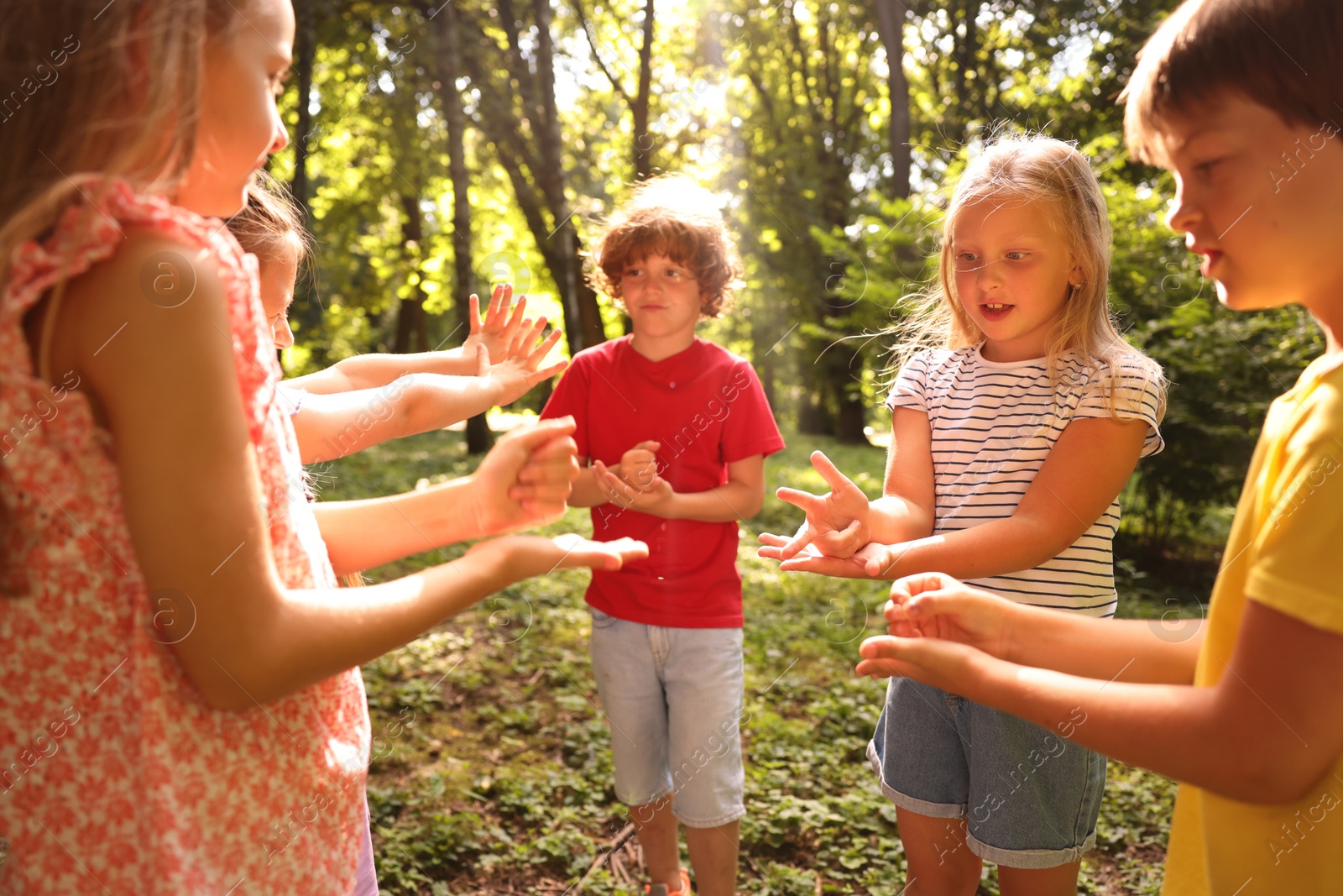 Photo of Cute little kids playing rock, paper and scissors in park