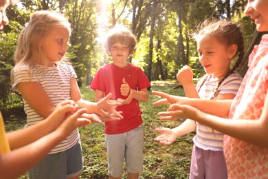 Photo of Cute little kids playing rock, paper and scissors in park