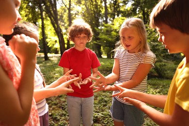 Photo of Cute little kids playing rock, paper and scissors in park