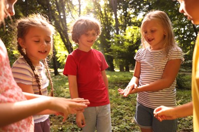 Photo of Cute little kids playing rock, paper and scissors in park
