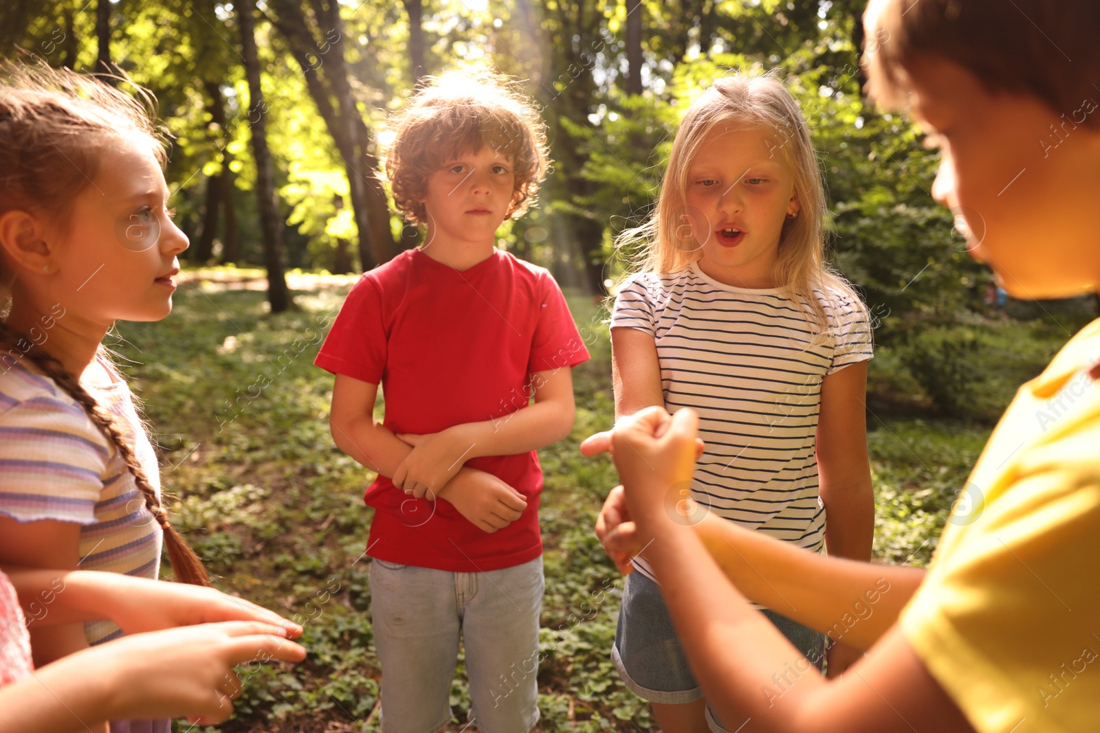 Photo of Cute little kids playing rock, paper and scissors in park