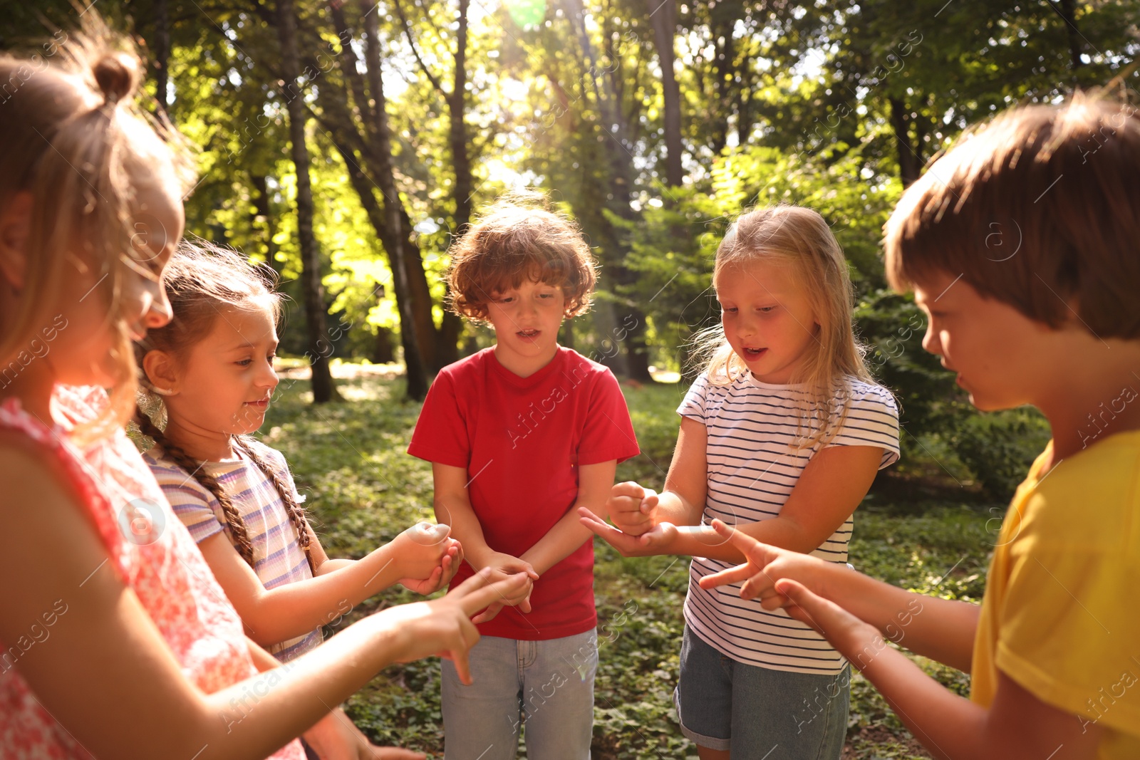 Photo of Cute little kids playing rock, paper and scissors in park