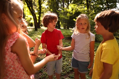Photo of Cute little kids playing rock, paper and scissors in park