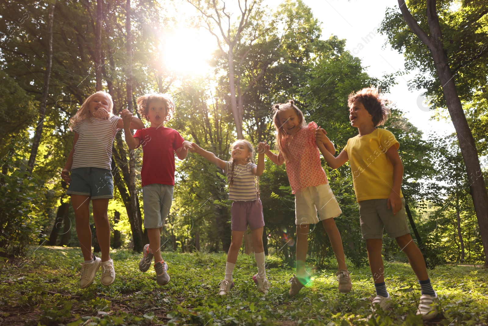 Photo of Cute little kids having fun together in park, low angle view