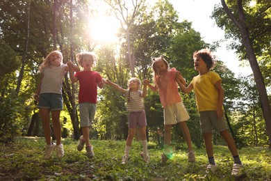 Photo of Cute little kids having fun together in park, low angle view
