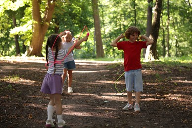 Photo of Cute little kids with jump ropes in park