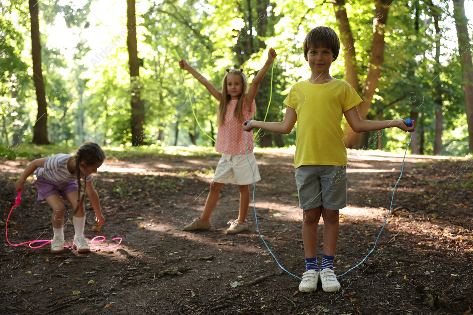 Photo of Cute little kids with jump ropes in park