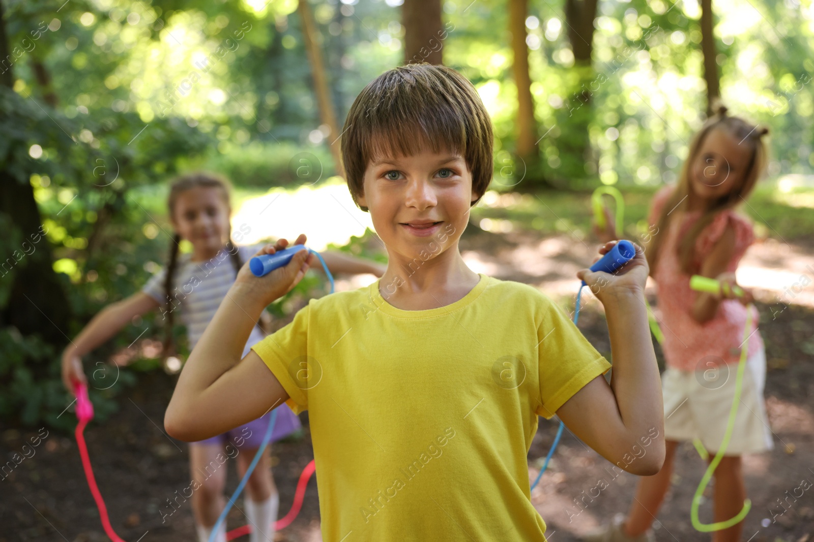 Photo of Cute little kids with jump ropes in park, selective focus