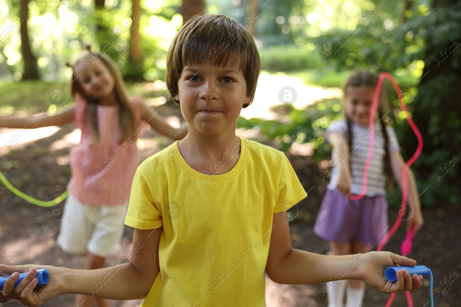 Photo of Cute little kids with jump ropes in park, selective focus