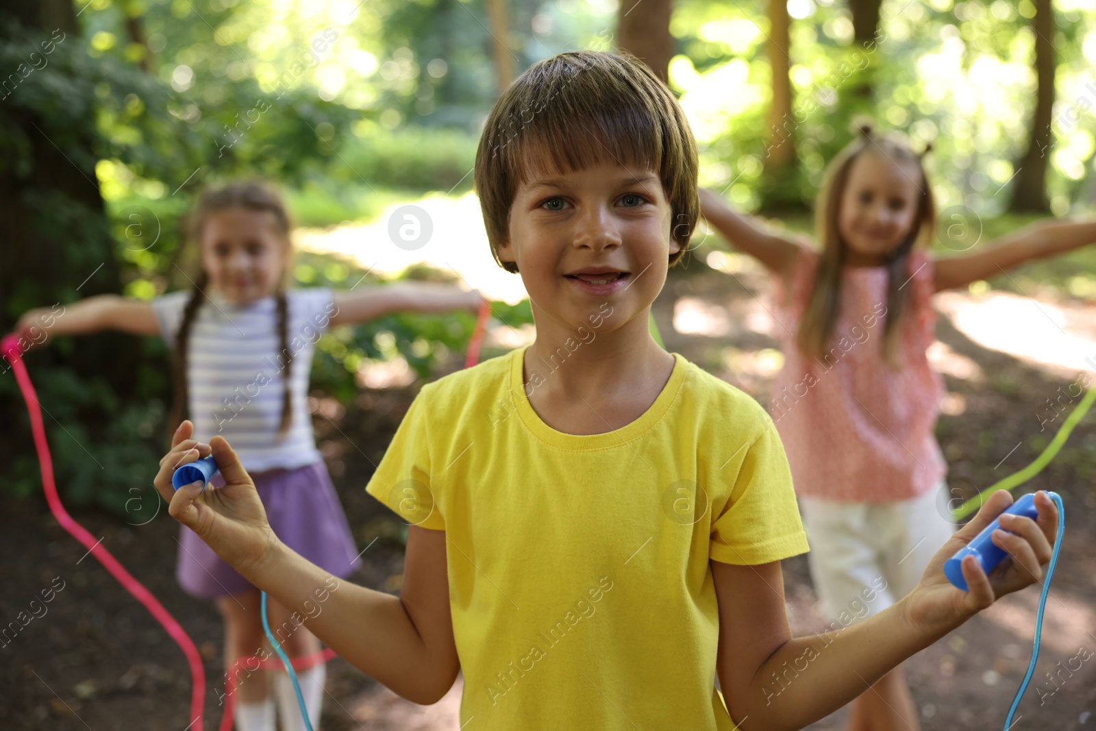Photo of Cute little kids with jump ropes in park, selective focus