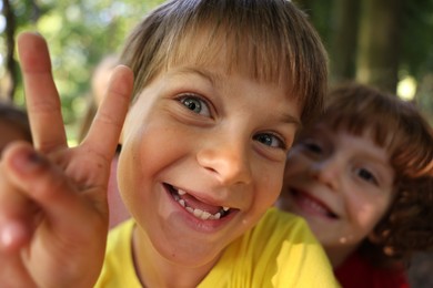 Photo of Cute little kids taking selfie in park, selective focus