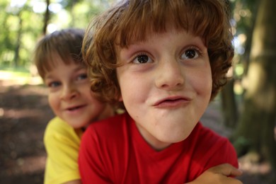 Photo of Cute little kids taking selfie in park, selective focus