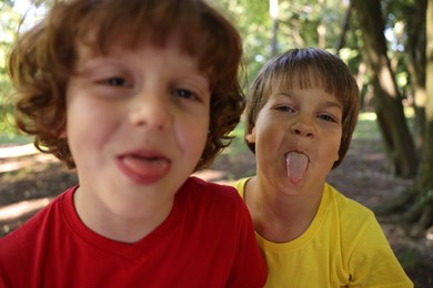 Photo of Cute little kids taking selfie in park, selective focus
