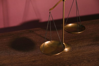 Photo of Scales of justice on table, closeup view
