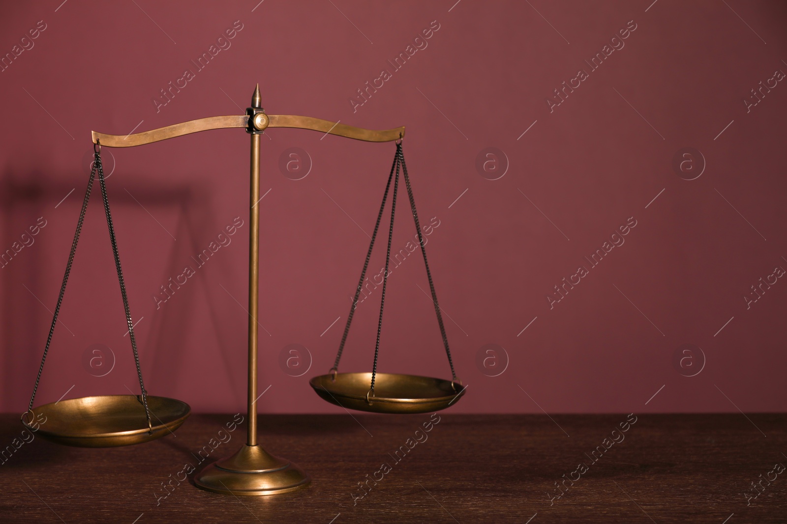 Photo of Scales of justice on table against dark background. Space for text