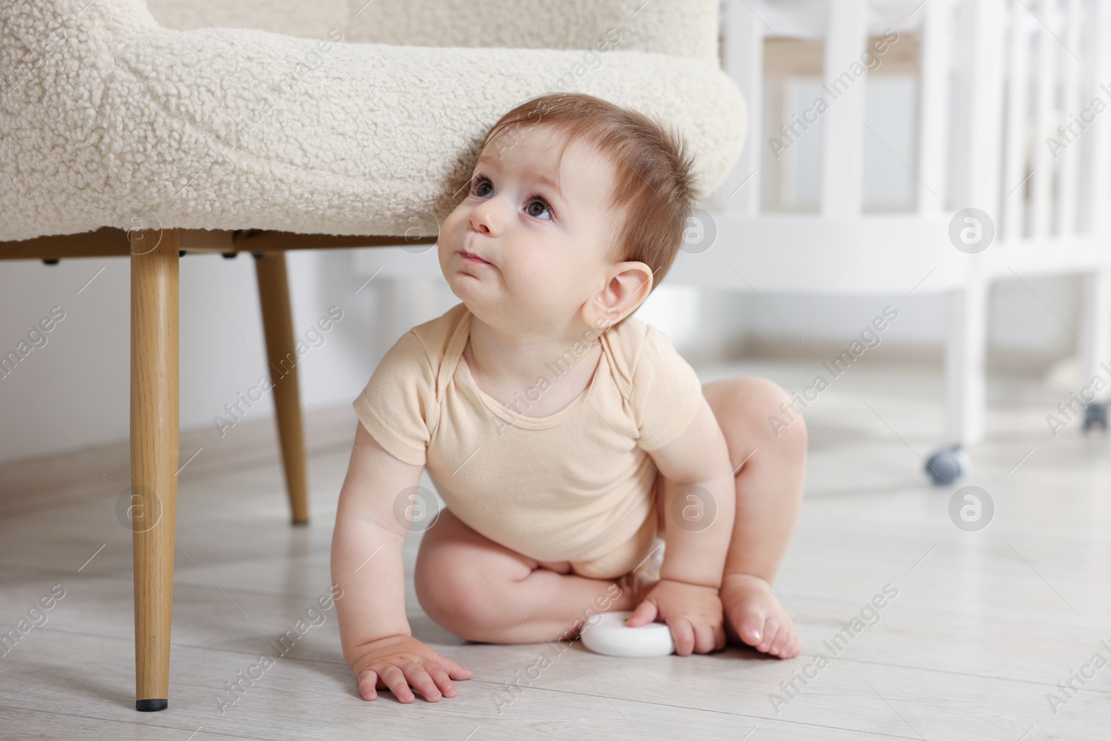 Photo of Cute little baby with toy in room