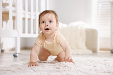 Photo of Cute little baby crawling on floor in room