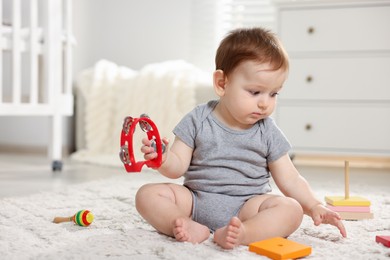 Photo of Cute little baby playing with toys in room