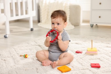 Photo of Cute little baby playing with toys in room