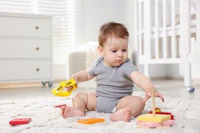 Photo of Cute little baby playing with toys in room