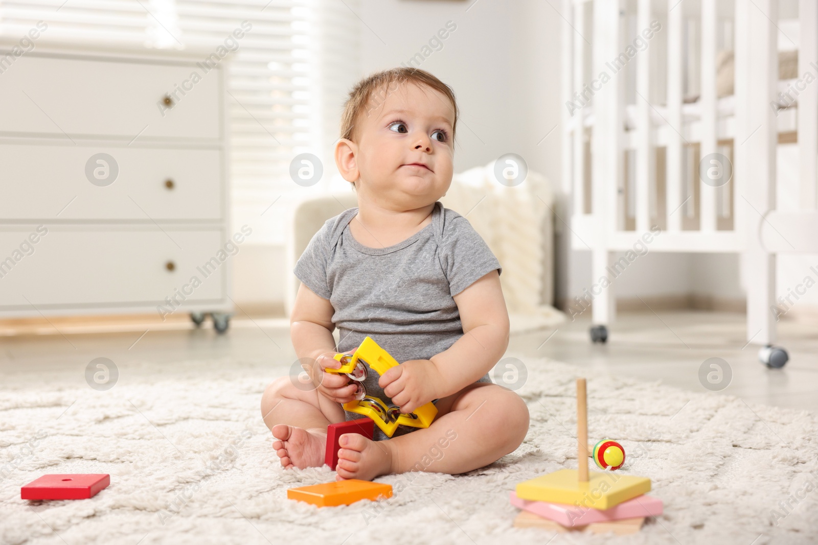 Cute little baby playing with toys in room Photo of Cute little baby playing with toys in room