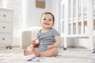 Photo of Cute little baby playing with toys in room