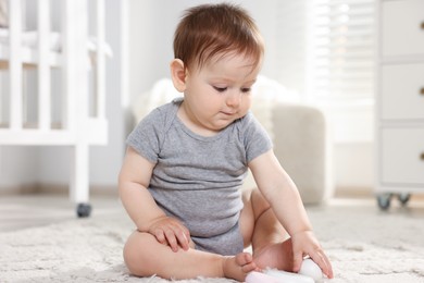 Photo of Cute little baby on floor in room